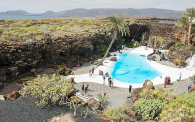 Jardín de Jameos del Agua in Lanzarote with turquoise pool and volcanic landscape.