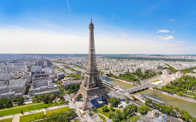 Aerial view of the Eiffel Tower in Paris with the Seine River and cityscape.