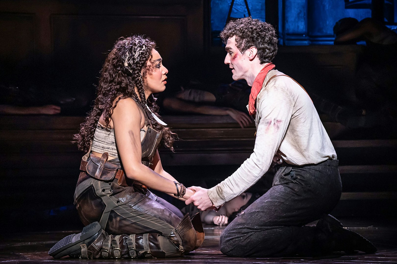 Two actors performing a scene in Hadestown musical, holding hands on stage.