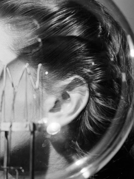 Profile of a woman with a lightbulb in front of her face.