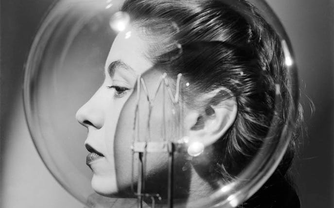 Profile of a woman with a lightbulb in front of her face.