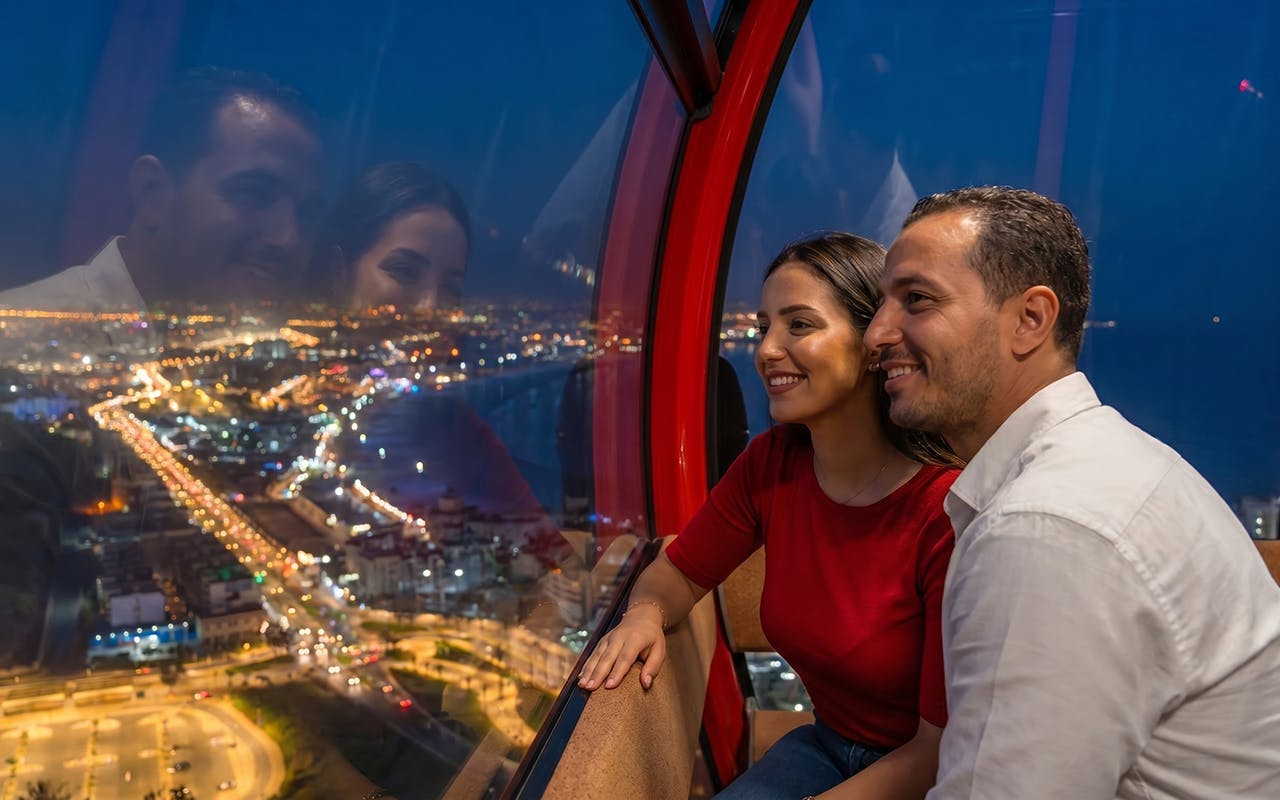 Couple enjoying city lights view from a night cable car.