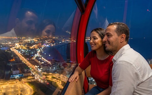 Couple enjoying city lights view from a night cable car.