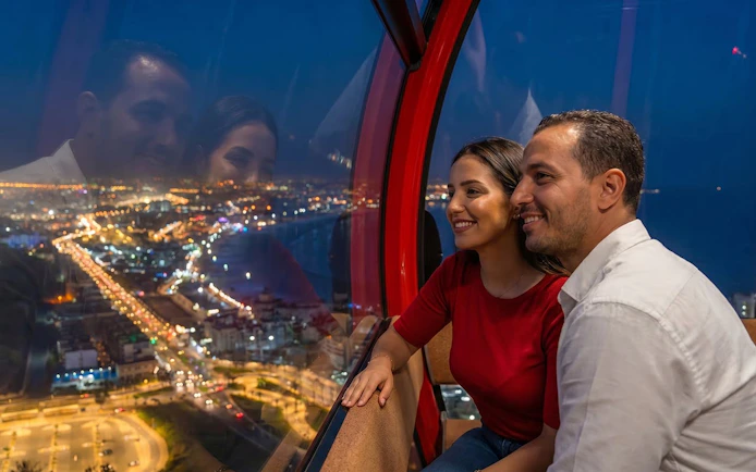 Couple enjoying city lights view from a night cable car.