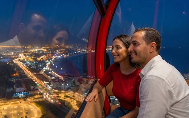 Couple enjoying city lights view from a night cable car.