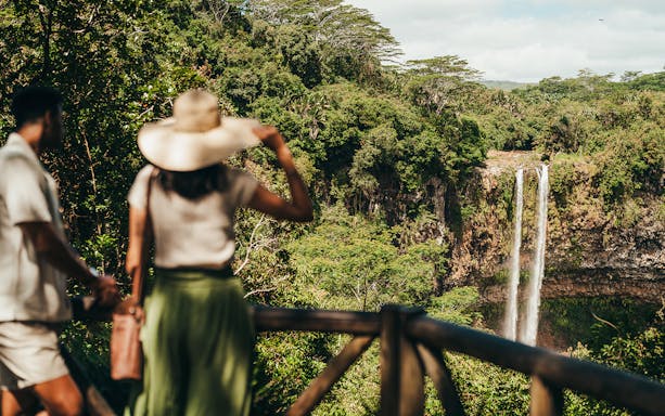 Visitors viewing Chamarel Waterfall on the 7 Coloured Earth plantation tour in Mauritius.