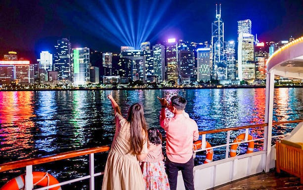 Family enjoying Hong Kong skyline from Star Ferry Harbor Tour at night.
