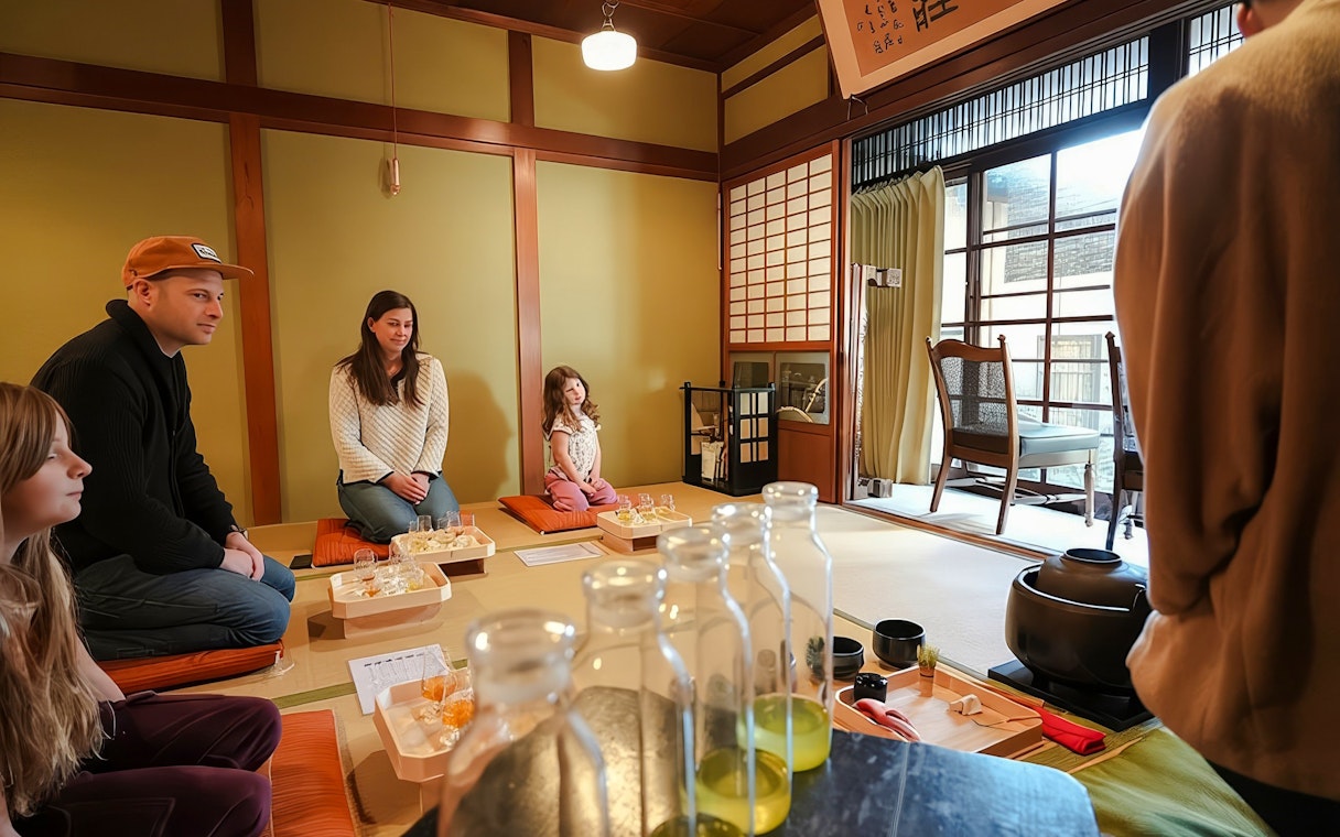 Tourists seated in a traditional Japanese house for a private tea ceremony with seasonal wagashi.