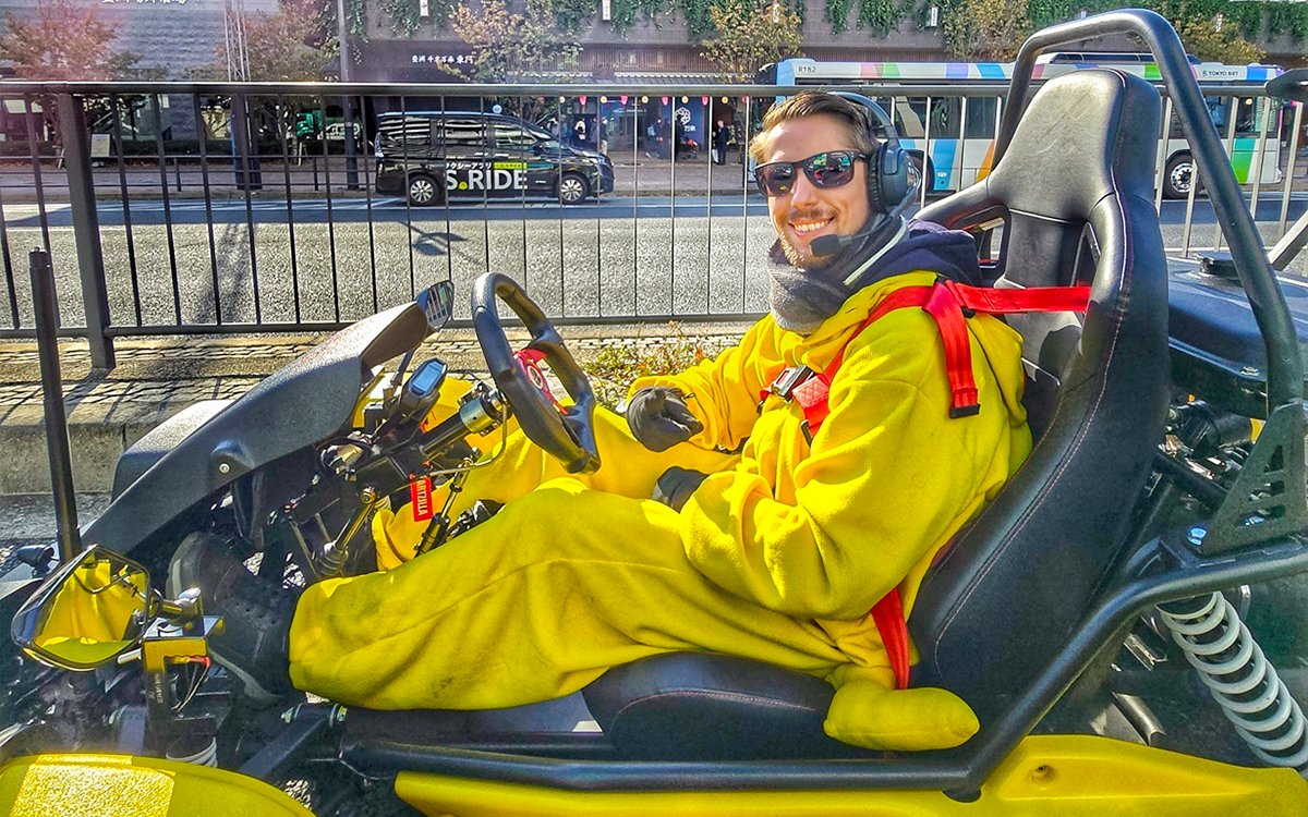 Person in costume driving a go-kart on Tokyo street during Skytree, Ginza, and Imperial Palace tour.