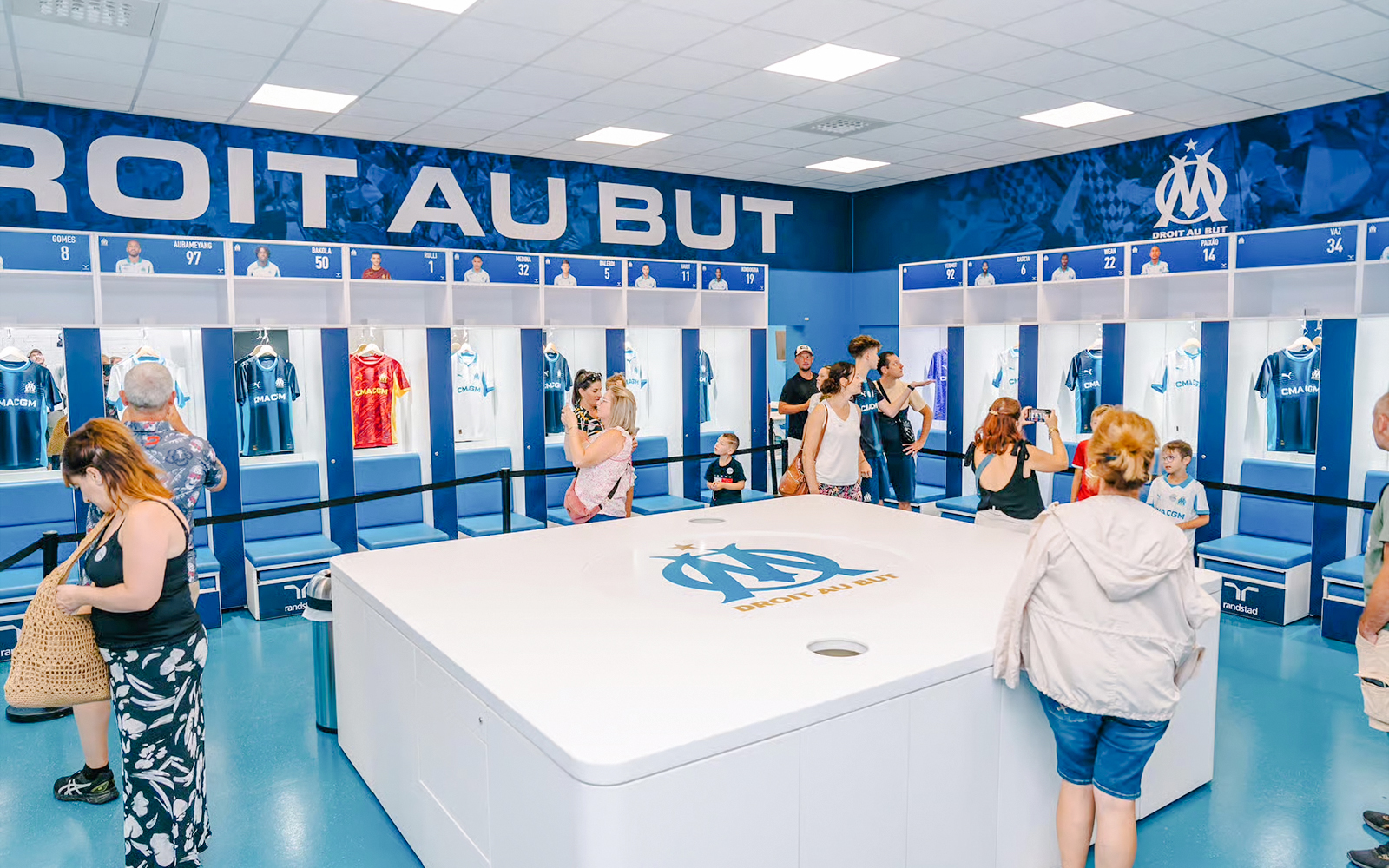 Visitors exploring the locker room during a Velodrome stadium tour in Marseille.