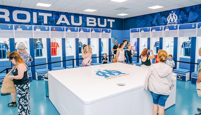 Visitors exploring the locker room during a Velodrome stadium tour in Marseille.