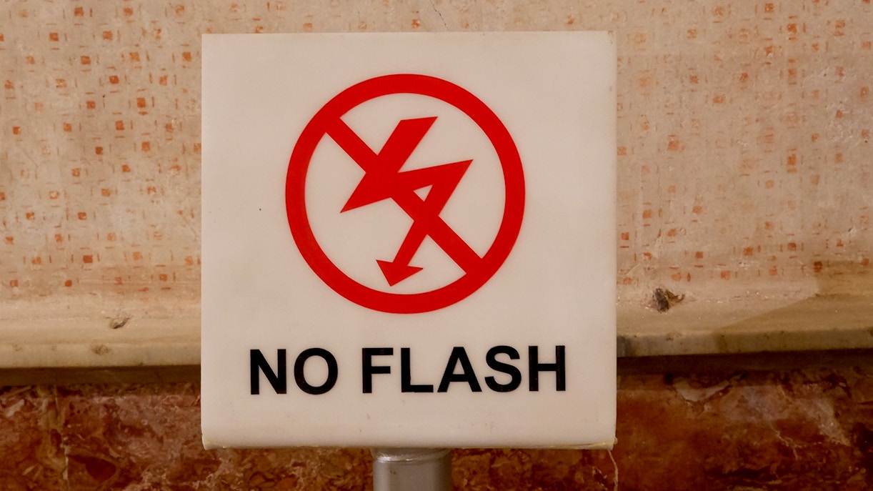 No flash photography sign at a tourist attraction.