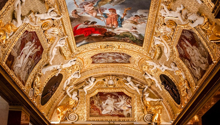 Louvre Museum ornate ceiling with classical paintings and sculptures, Paris, France.