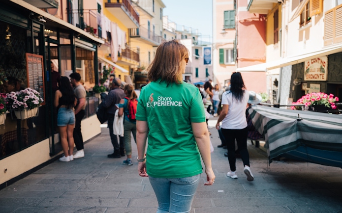 Tourists exploring a vibrant street in Cinque Terre, Italy.