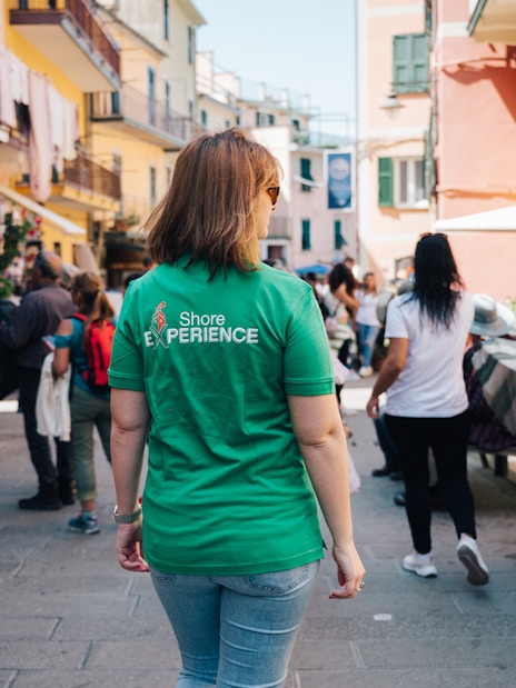 Tourists exploring a vibrant street in Cinque Terre, Italy.