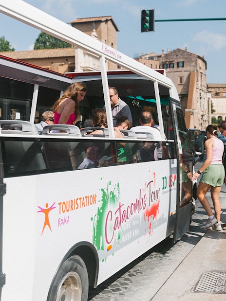 Tourists boarding a bus for a guided tour of the Catacombs in Rome.