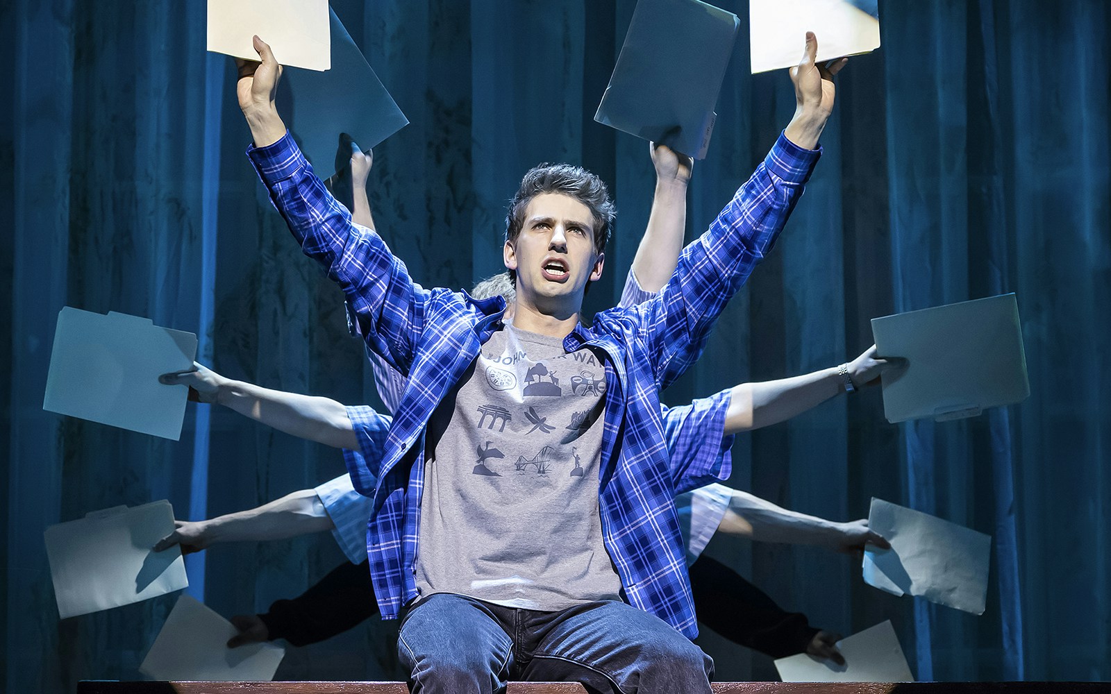 Performer on stage holding folders during Clueless The Musical.