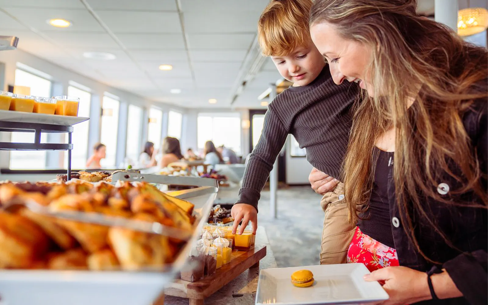 Mother and child selecting food on San Diego brunch cruise buffet.