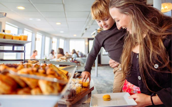Mother and child selecting food on San Diego brunch cruise buffet.