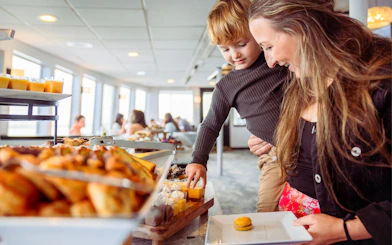 Mother and child selecting food on San Diego brunch cruise buffet.