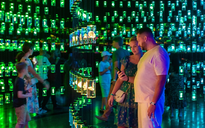Visitors exploring the Library of Life exhibit at Dubai Museum of the Future, surrounded by illuminated displays.
