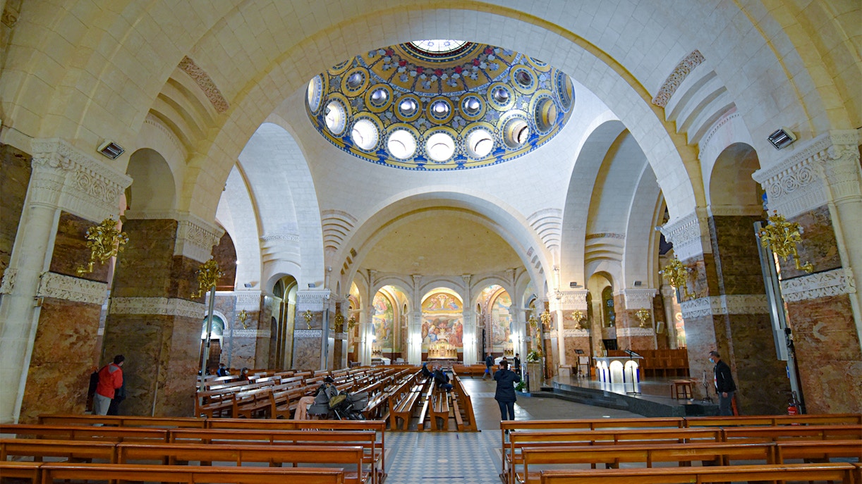 Vatican Grottoes with visitors exploring historic tombs beneath St. Peter's Basilica, Vatican City.