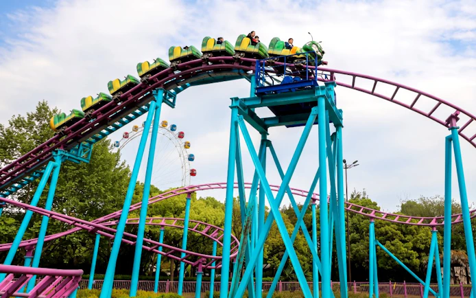 Roller coaster at Shanghai Wild Animal Park with Ferris wheel in background.