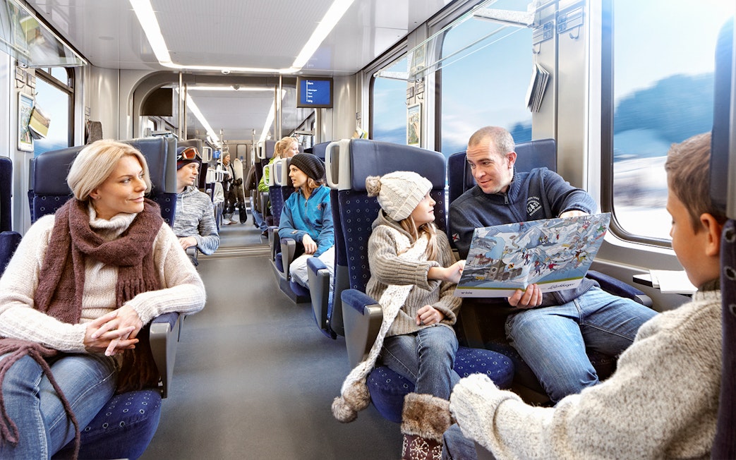 Family enjoying scenic train ride in Switzerland with Interrail pass.