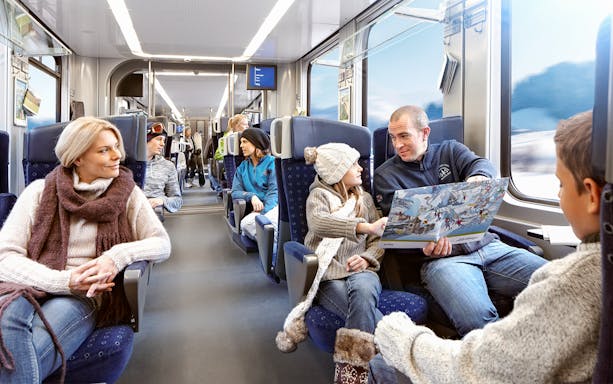 Family enjoying scenic train ride in Switzerland with Interrail pass.