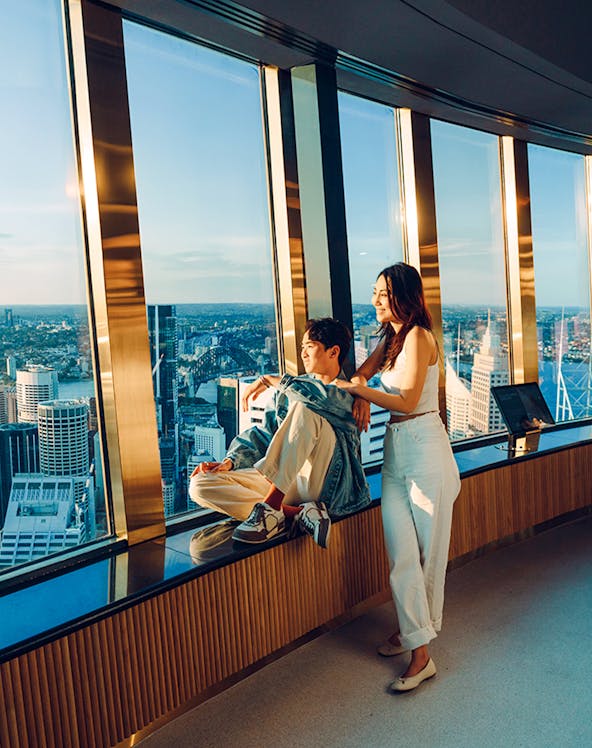 Couple enjoying view from Sydney Tower Eye observation deck.