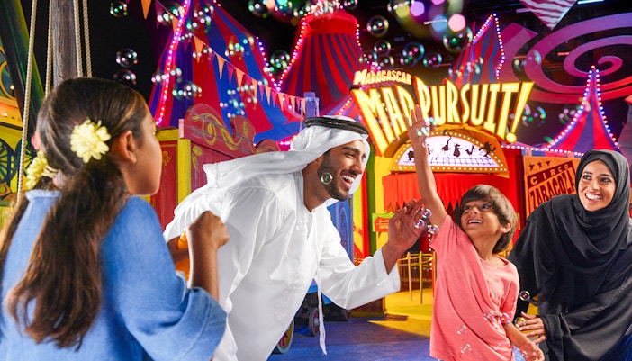 Roller coaster at MOTIONGATE™ Dubai theme park with vibrant lights and limited time ticket offer.