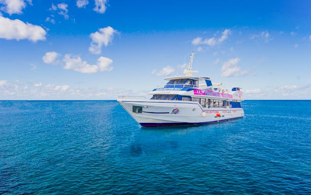 Ferry on blue ocean between Fuerteventura and Lanzarote under clear sky.