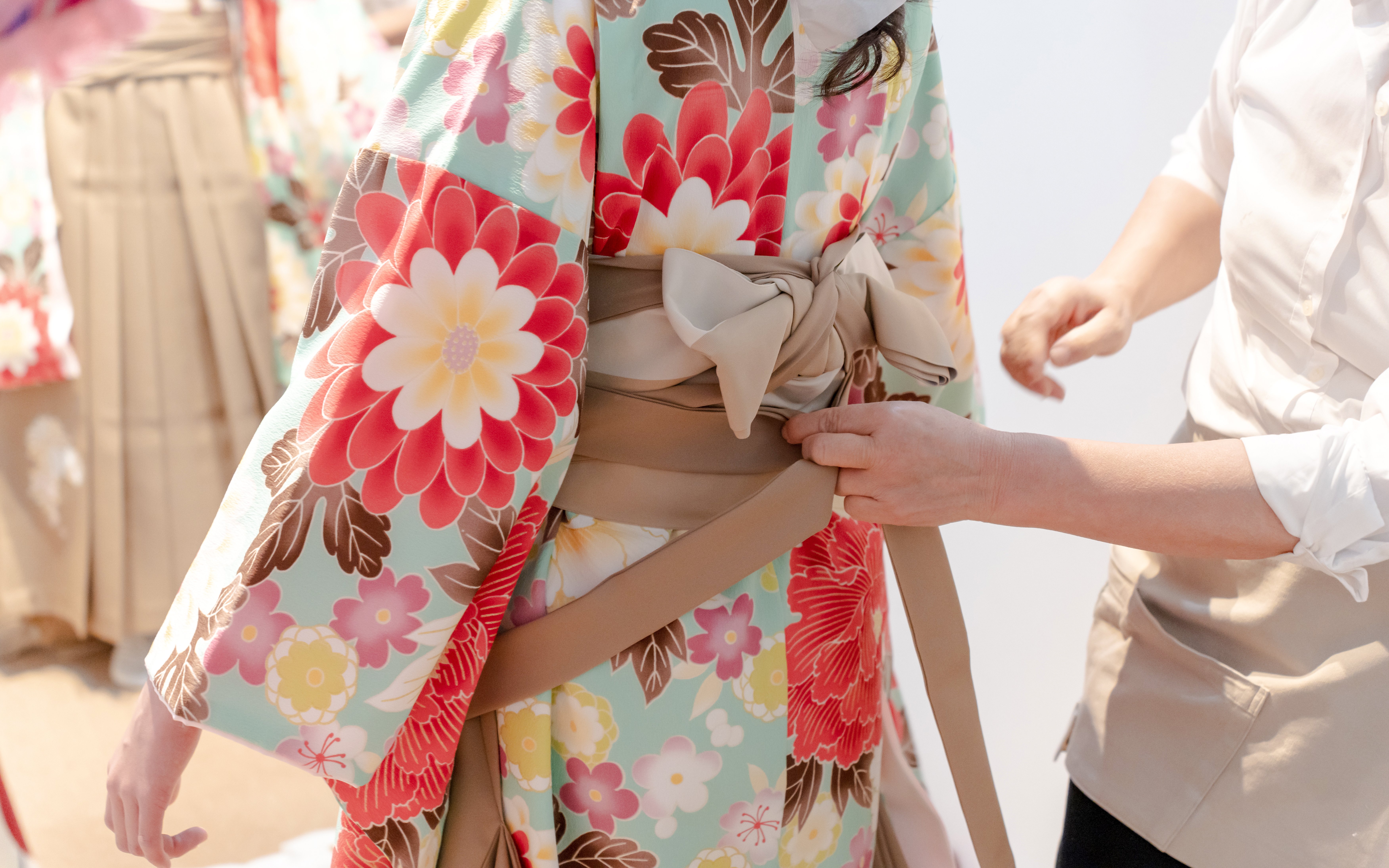 Kimono being tied with an obi during a rental fitting in Tokyo.