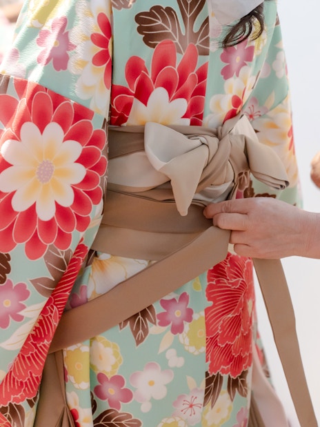 Kimono being tied with an obi during a rental fitting in Tokyo.