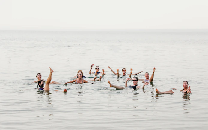 Women floating in the Dead Sea, Jordan, enjoying the buoyant waters.