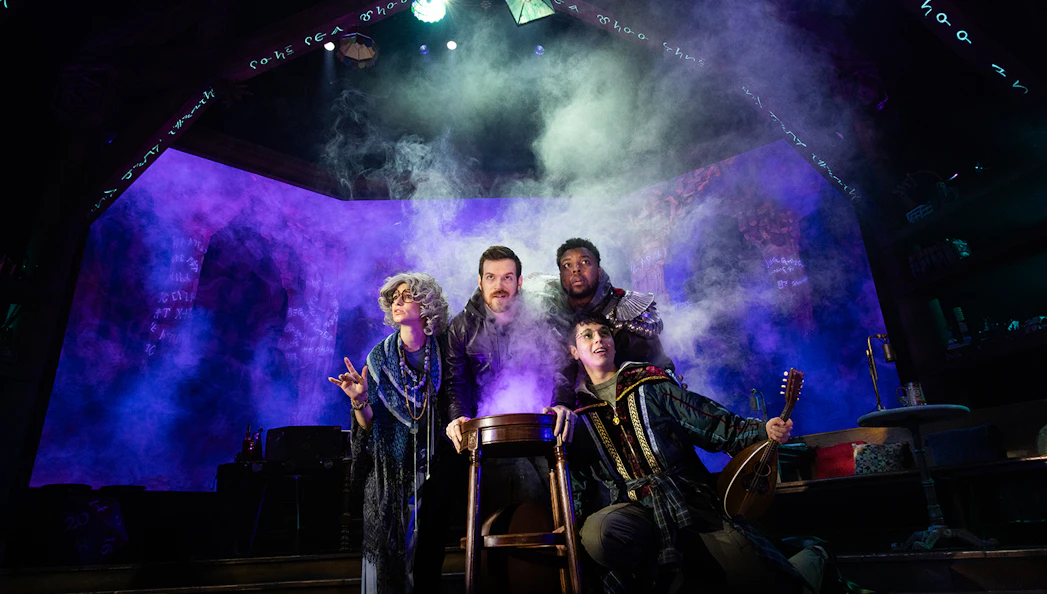 Actors in fantasy costumes perform in a smoky tavern setting for Dungeons & Dragons: The Twenty-Sided Tavern.