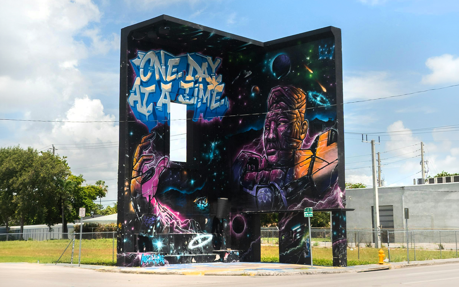 Wynwood Walls mural featuring space-themed art and "One Day at a Time" text in Miami, Florida.