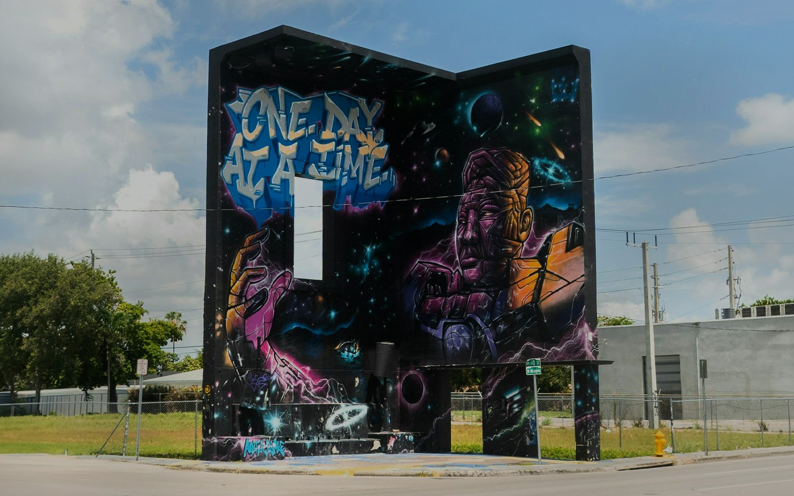 Wynwood Walls mural featuring space-themed art and "One Day at a Time" text in Miami, Florida.