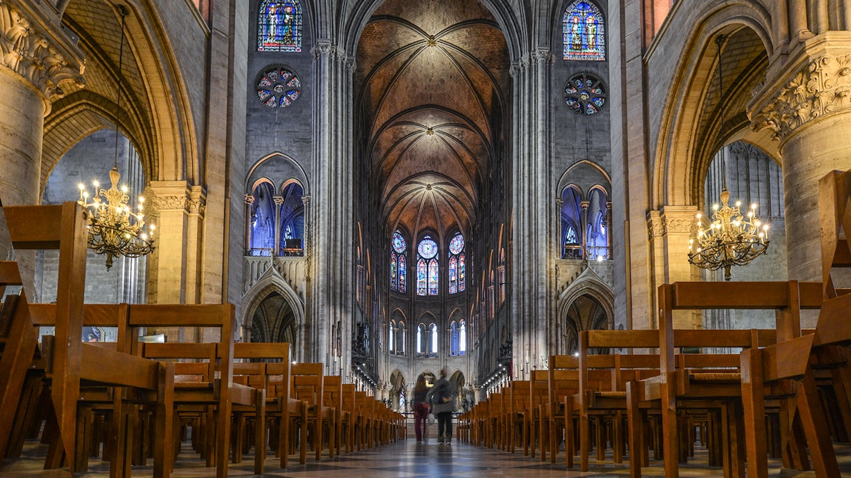 Notre Dame Cathedral facade with sculptures, part of Paris tour including Louvre and Eiffel Tower lunch.