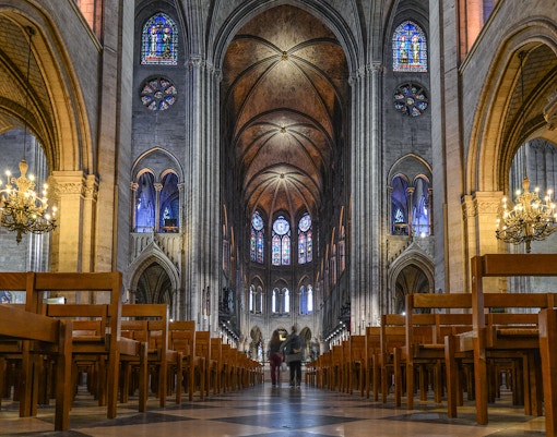 Notre Dame Cathedral facade with sculptures, part of Paris tour including Louvre and Eiffel Tower lunch.
