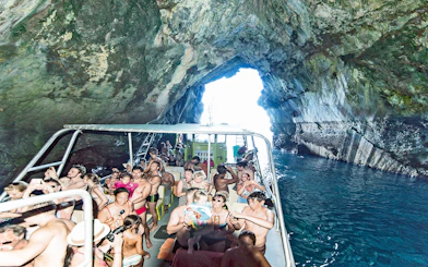 Boat tour with people exploring a cave in Alcudia, Mallorca.