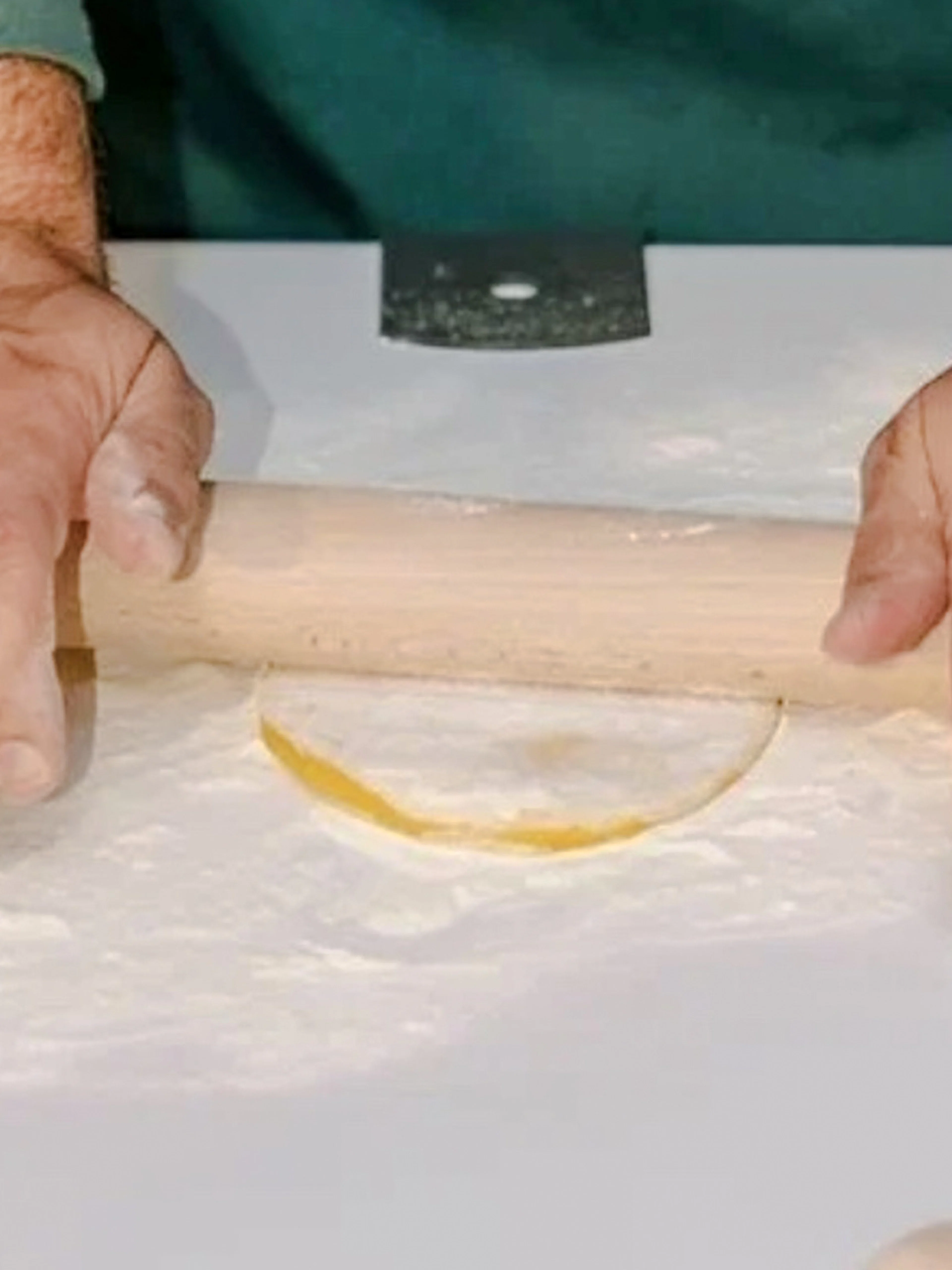 Hands rolling pasta dough during a cooking class in Rome.