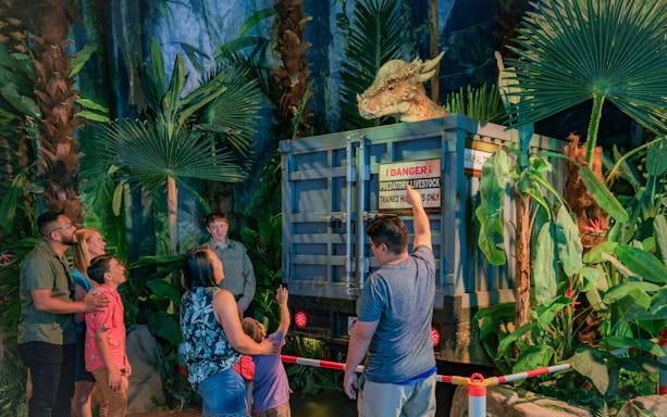 Visitors observing a dinosaur exhibit at Jurassic World: The Exhibition in Melbourne.