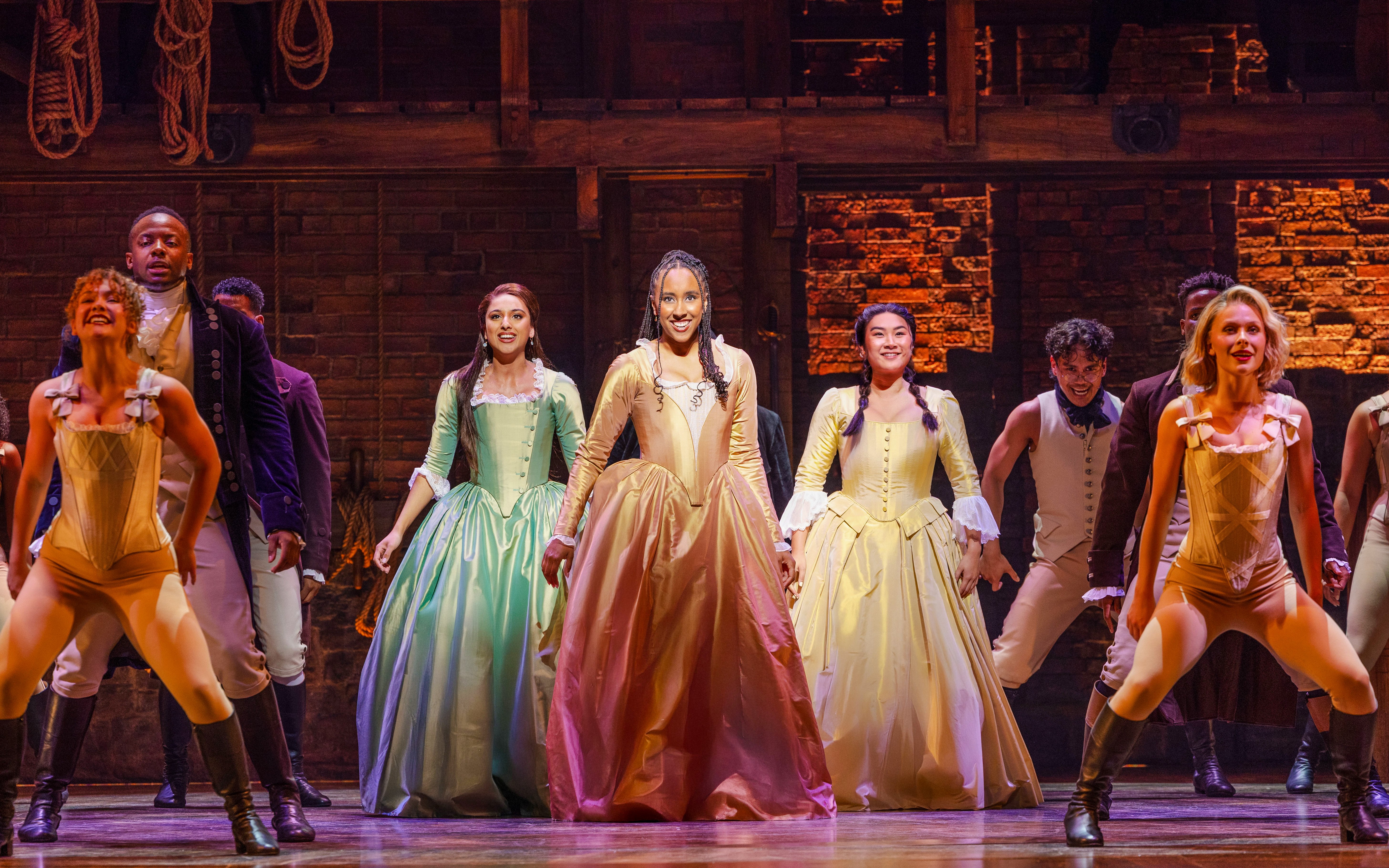 Cast performing on stage in a scene from the musical Hamilton.