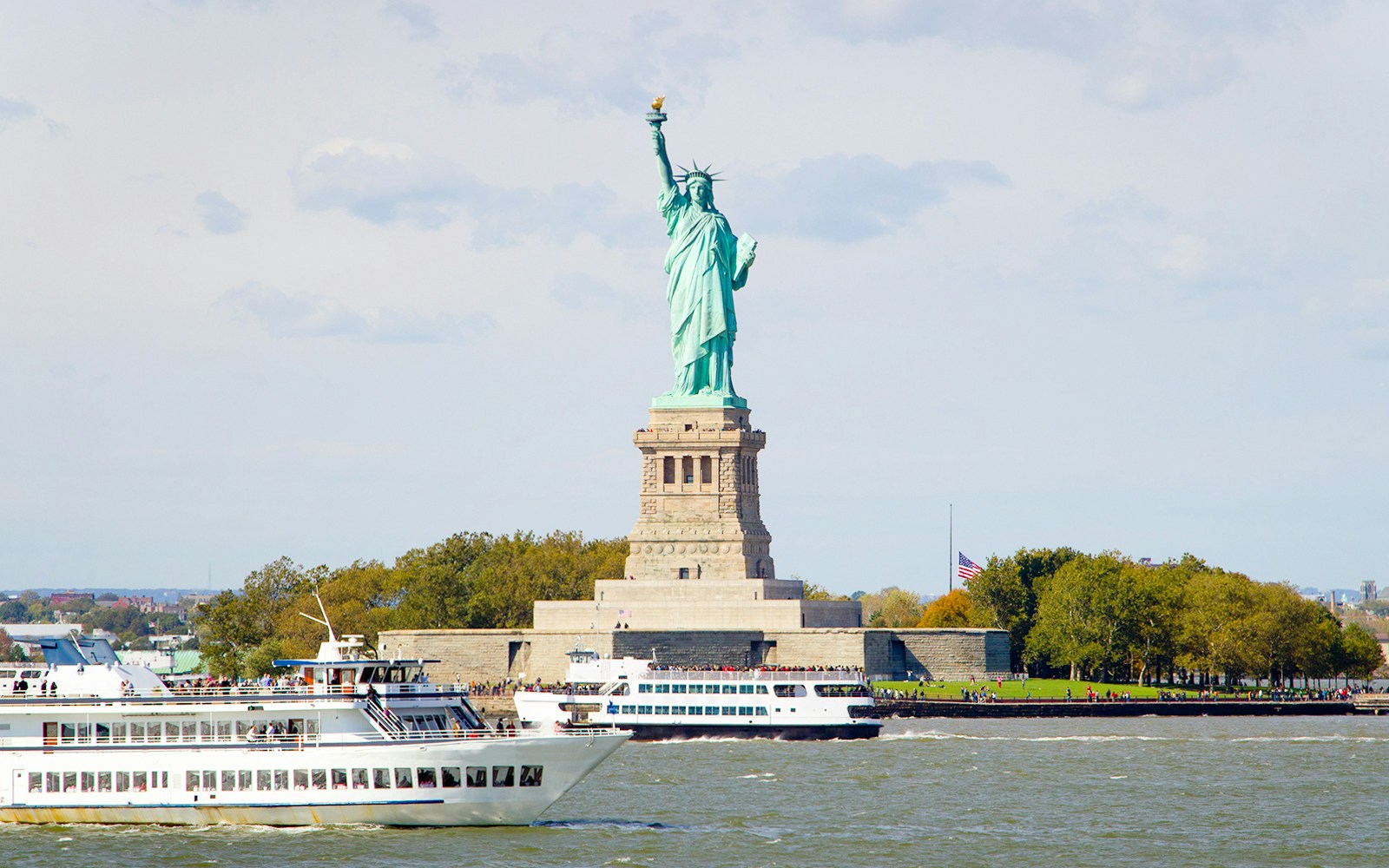Statue of Liberty sightseeing cruise with tourists on deck, New York City.