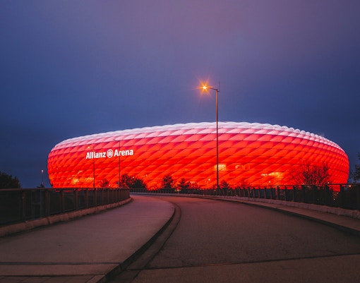 Allianz Arena exterior in Munich, Germany, with illuminated facade at night.