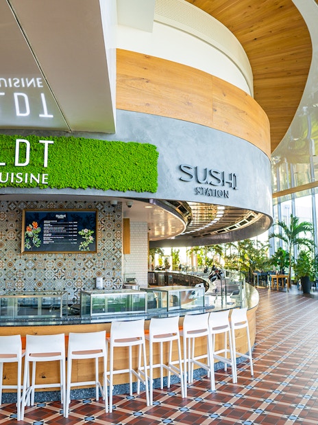 Sushi restaurant interior at Therme Bucuresti with seating and greenery.