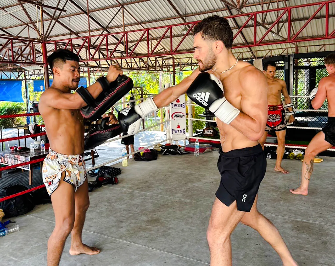 Muay Thai training session in Phuket gym with beginners practicing punches.