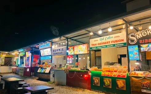Street food stalls at night in Chiang Mai, featuring Thai desserts and snacks.