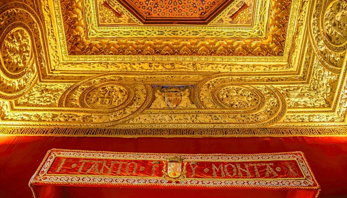 Ornate gold ceiling with intricate carvings at Alcazar of Segovia, Spain.